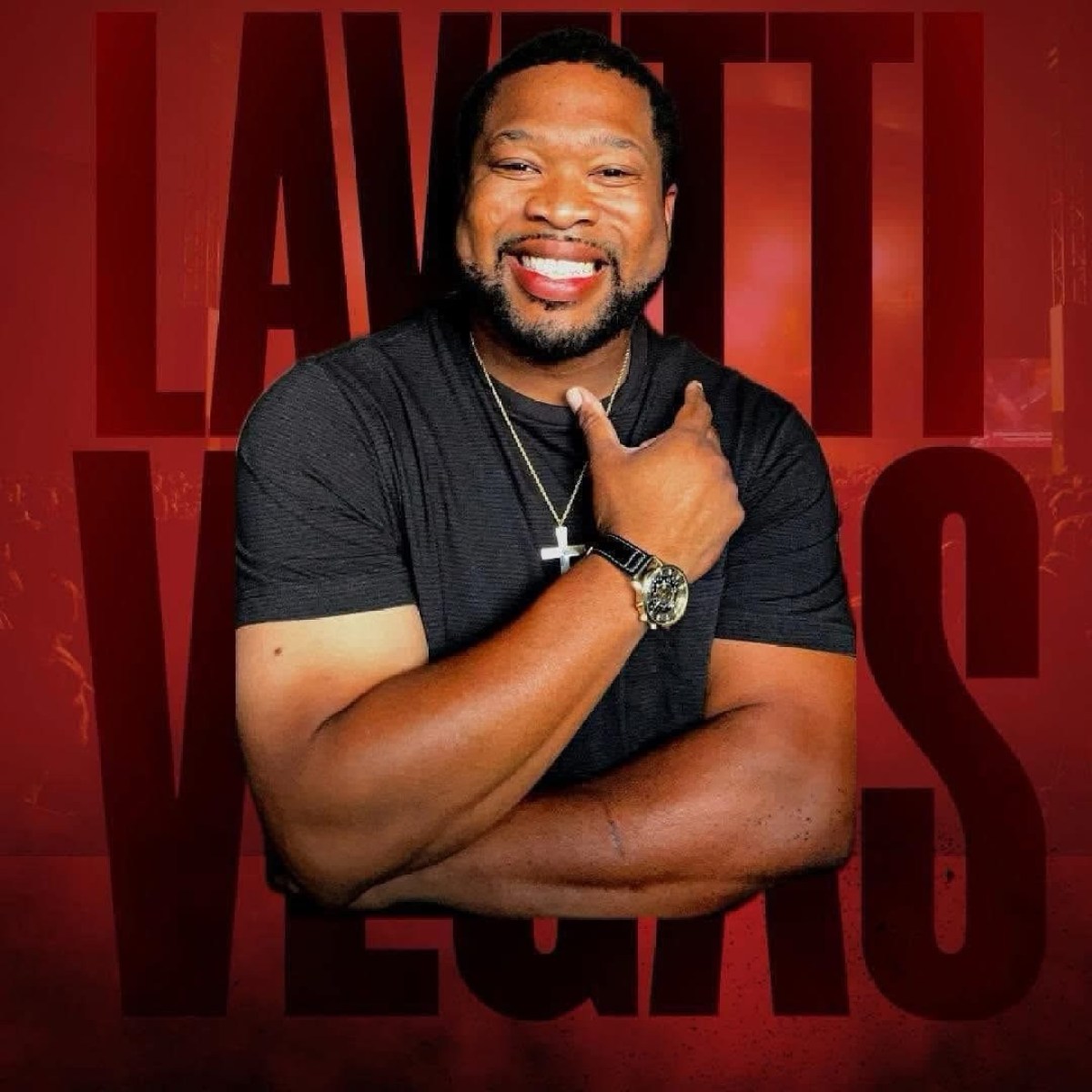 Smiling man in black shirt with cross necklace, arms crossed, red text background.