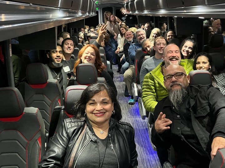 Group of people smiling and posing for a photo inside a bus.